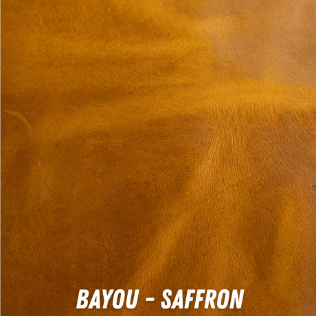 A close-up of a textured leather-like surface in a warm golden tan shade, with the text 'BAYOU - SAFFRON' at the bottom.