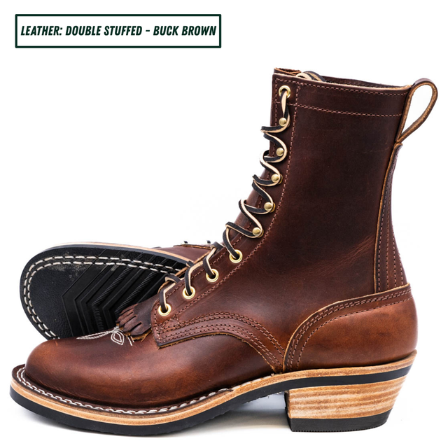 A pair of brown double-stuffed leather lace-up boots shown on a white background, with one boot standing upright and the other lying on its side to display the sole. A text label in the top-left corner reads 'LEATHER: DOUBLE STUFFED - BUCK BROWN'.