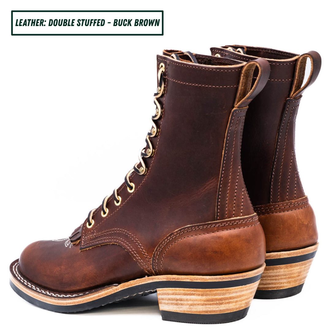 A brown double-stuffed leather lace-up boot with a stacked wood-look heel, shown in profile on a white background. A text label in the top-left corner reads 'LEATHER: DOUBLE STUFFED - BUCK BROWN'.