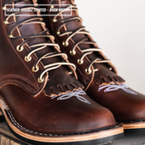 A close-up of a pair of double-stuffed buck brown leather lace-up boots with fringe detailing and white embroidered patterns near the toes, shown on a neutral background with a text overlay at the top.