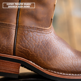 Close-up of a brown leather boot showing the textured grain and stitching, with a text label in the top left reading 'LEATHER: PREDATOR ORANGE/ SHRUNKEN BISON BROWN'.