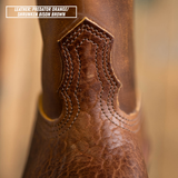 Close-up of a textured brown leather boot shaft with decorative stitching and a text label in the top-left corner reading 'LEATHER: PREDATOR ORANGE/ SHRUNKEN BISON BROWN'.