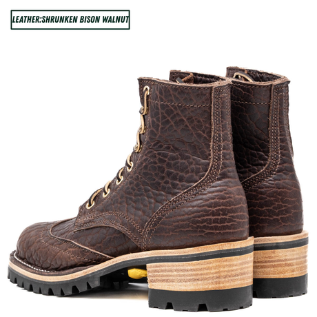 A pair of dark brown leather lace-up boots with a textured, shrunken finish and stacked wooden heels, shown against a plain white background with a text label in the top left corner.