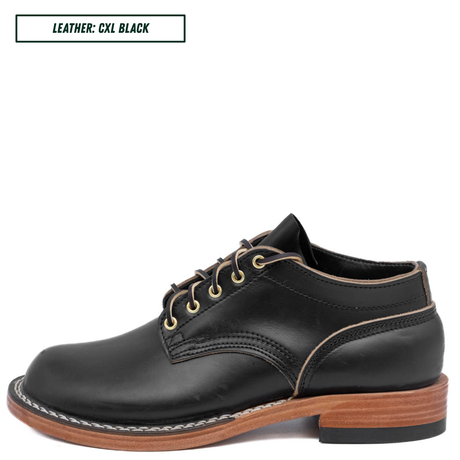 A black leather lace-up dress shoe with gold-toned laces and contrast stitching, shown from a side profile on a white background. A text box in the top-left corner reads 'LEATHER: CXL BLACK'.