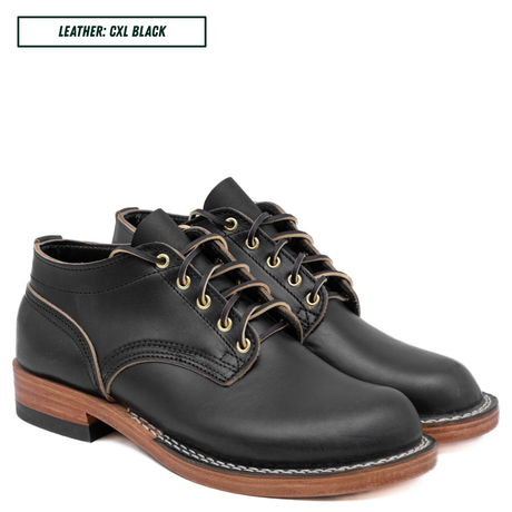 A pair of black leather lace-up ankle boots with gold-tone eyelets, white contrast stitching, and brown stacked soles, shown on a white background with a text label reading 'LEATHER: CXL BLACK'.