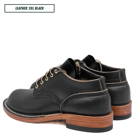 A pair of black leather lace-up shoes with light tan contrast stitching and stacked brown wooden heels, shown on a white background with a text label in the top left reading 'LEATHER: CXL BLACK'.