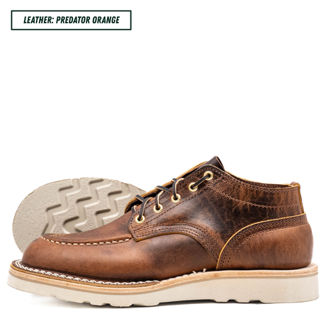 A single brown leather lace-up shoe shown in side profile on a white background, with a second shoe placed behind it to display the outsole. A text label in the top left reads 'LEATHER: PREDATOR ORANGE'.
