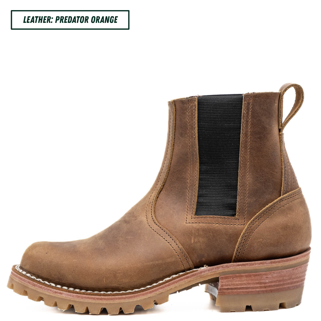 A brown leather Chelsea-style ankle boot with a black elastic side panel and a stacked lug sole, shown on a white background with a text label reading 'LEATHER: PREDATOR ORANGE'.