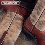 Close-up of a pair of western boots showing mixed leather panels in natural tan and reddish-brown, with a text label reading 'LEATHER: PREDATOR NATURAL / MINOTAUR BULLHIDE BROWN'.