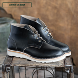 Black leather boots sitting on crate. A text box in the top left corner reads 'LEATHER: CXL BLACK'.