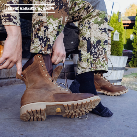 Model sits on porch, putting on brown leather boots. Top left reads 'LEATHER: WEATHERSHIELD BROWN'.