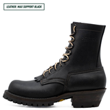 A black leather lace-up work boot shown in profile against a white background, with a text label in the top-left corner reading 'LEATHER: MAX SUPPORT BLACK'. The boot features a rugged lug sole, a stacked heel, and metal eyelets.