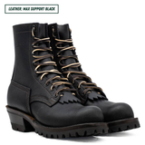 A black leather lace-up work boot shown in profile against a white background, with a text label in the top-left corner reading 'LEATHER: MAX SUPPORT BLACK'. The boot features a rugged lug sole, a stacked heel, and metal eyelets.