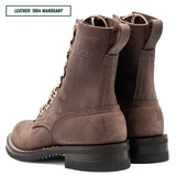 A pair of brown suede lace-up boots shown from the side and back on a white background, with a text label in the top-left corner reading 'LEATHER: 1964 MAHOGANY'.