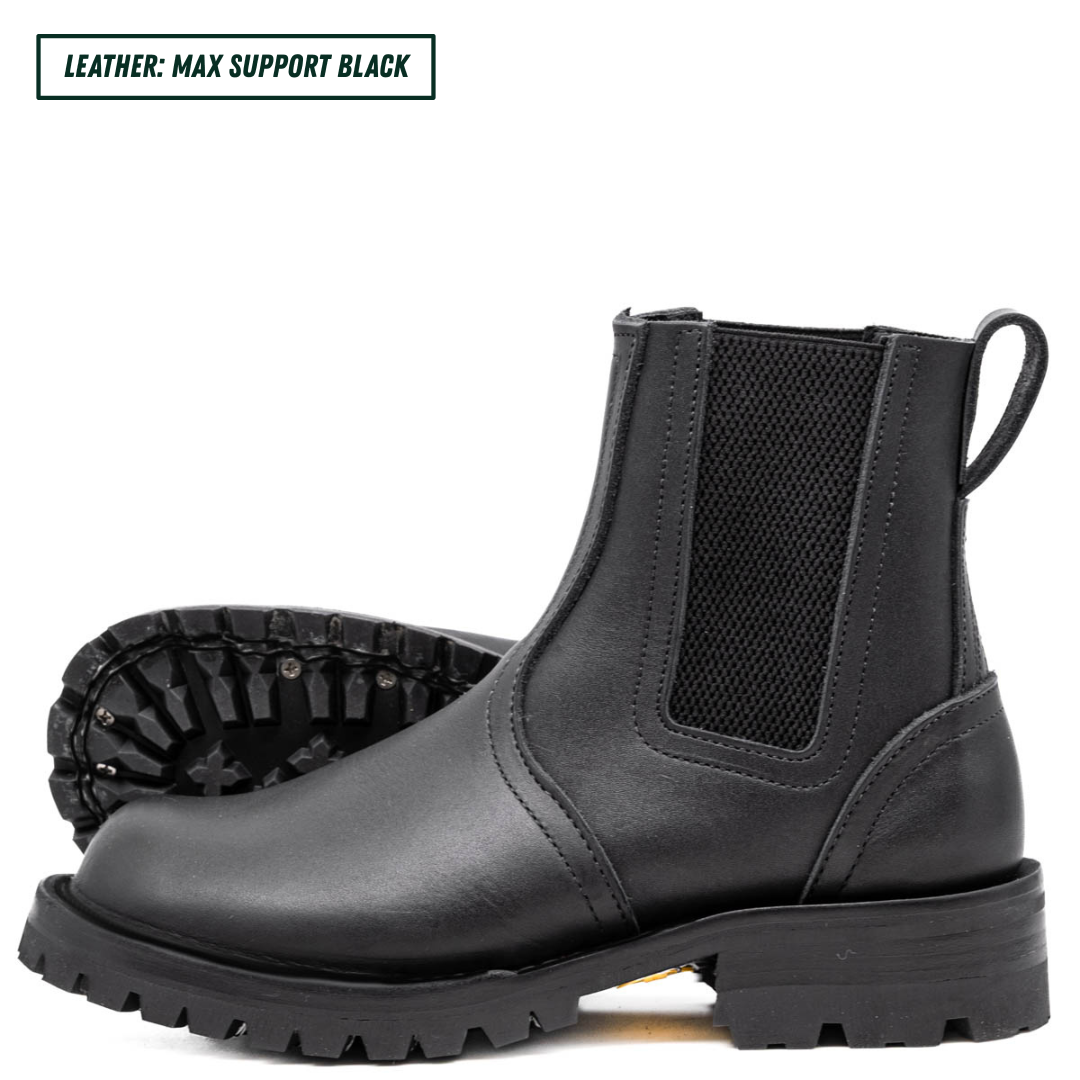 Blackout Chelsea boots, one sitting upright showing the side profile while the other lays down showing the outsole. Top left reads 'LEATHER: MAX SUPPORT BLACK'.
