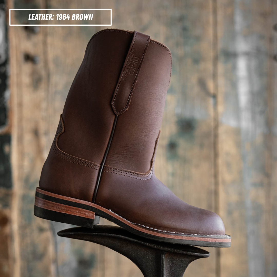 A brown leather cowboy boot shown in profile on a metal boot jack against a rustic wooden plank background. A text overlay in the top-left corner reads 'LEATHER: 1964 BROWN'.