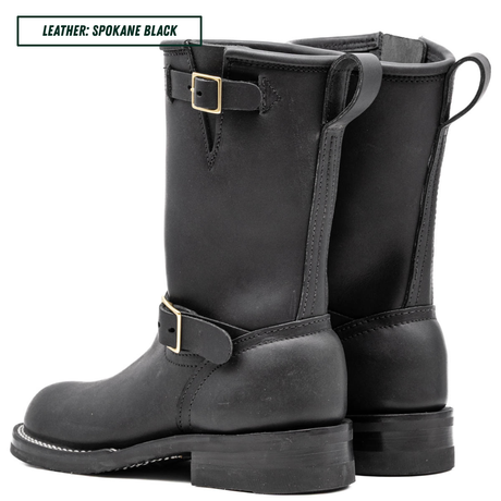 A pair of black leather mid-calf boots with buckle straps, shown from the side and back on a white background. A text label in the top-left corner reads 'LEATHER: SPOKANE BLACK'.