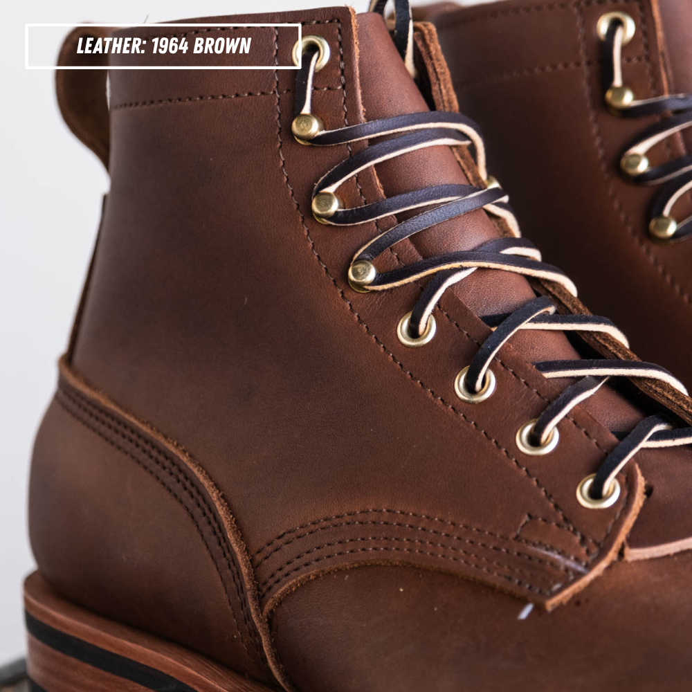 Close-up of a brown leather lace-up boot with dark laces and brass eyelets, with a text overlay reading 'LEATHER: 1964 BROWN'.