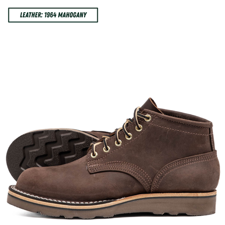 A pair of dark brown leather lace-up boots shown on a white background, with one boot standing upright and the other lying on its side to display the tread. A text label in the top left reads 'LEATHER: 1964 MAHOGANY'.