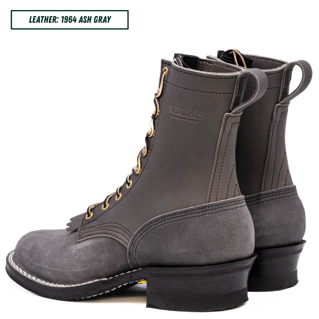 A pair of dark gray leather lace-up boots shown from the side and back on a white background, with a text label in the top-left corner reading 'LEATHER: 1964 ASH GRAY'.