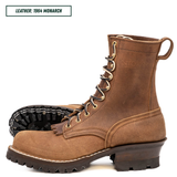 A pair of brown leather lace-up boots shown on a white background, with one boot standing upright and the other lying on its side to display the black treaded sole. A text label in the top left reads 'LEATHER: 1964 MONARCH'.