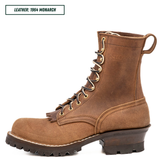 A brown leather lace-up boot shown in profile on a white background, with a text label in the top-left corner reading 'LEATHER: 1964 MONARCH'. The boot has tan eyelets, a pull loop at the heel, and a rugged dark sole.