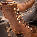Close-up of a brown leather lace-up boot with distressed texture, gold-tone eyelets, and dark laces. Another boot is blurred in the background, and a text label reads 'LEATHER: 1964 MONARCH & 1964 ASH GRAY'.