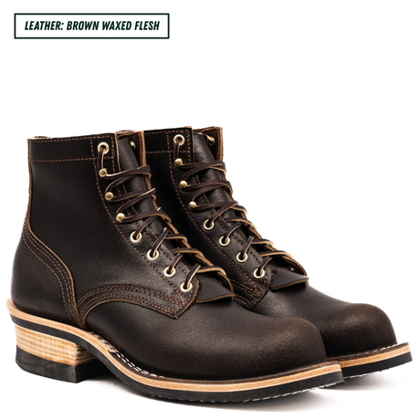 A pair of dark brown waxed leather lace-up boots with gold-toned metal eyelets and stacked wood-look heels, shown on a white background with a text label reading 'LEATHER: BROWN WAXED FLESH'.