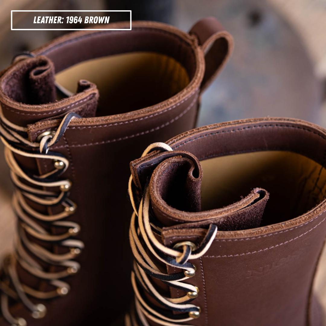 Close-up of a pair of lace-up boots in dark brown leather with silver metal eyelets and laces, showing the interior lining and collar detail. A text label in the top left reads 'LEATHER: 1964 BROWN'.