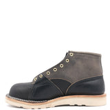 Photograph of the right inside of a gray and dark navy blue boot with leather details and an inside lineman patch on a white background