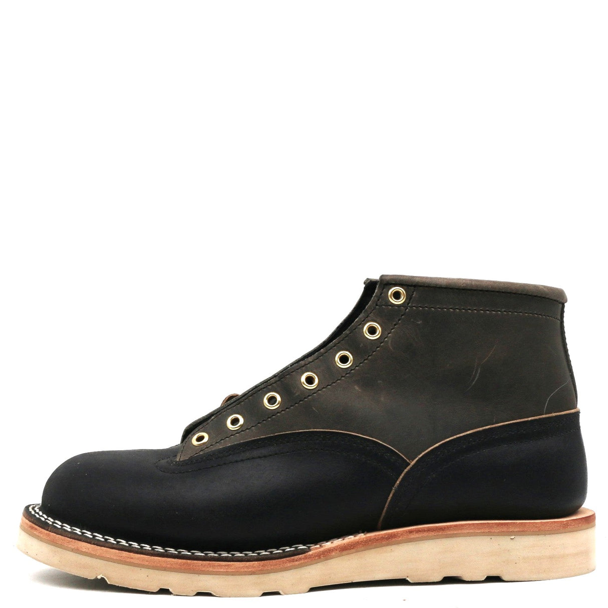 Grey and dark navy blue leather boot with brass hardware and a white wedge outsole in front of a white background.