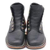 A pair of black leather lace-up ankle boots with gold-tone metal eyelets and white contrast stitching on the soles, shown against a plain white background.