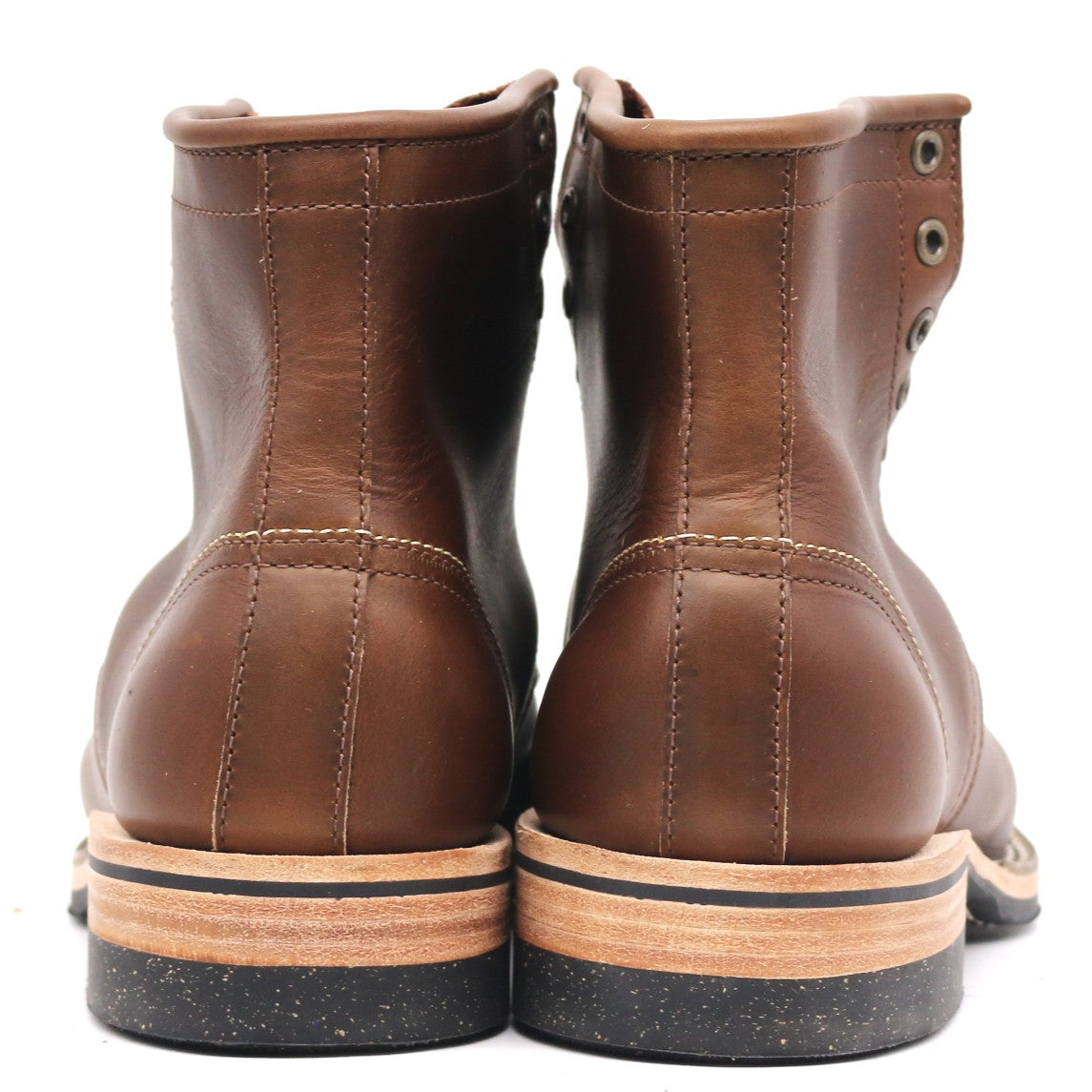 A pair of brown leather lace-up ankle boots shown from the back, featuring light tan midsoles with black rubber outsoles, set against a plain white background.