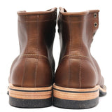 A pair of brown leather lace-up ankle boots shown from the back, featuring light tan midsoles with black rubber outsoles, set against a plain white background.