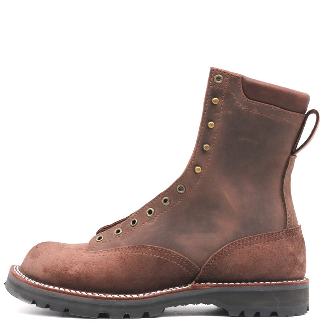 A brown leather lace-up work boot with brass eyelets, a pull tab, and a thick black lug sole, shown from a side profile on a white background.