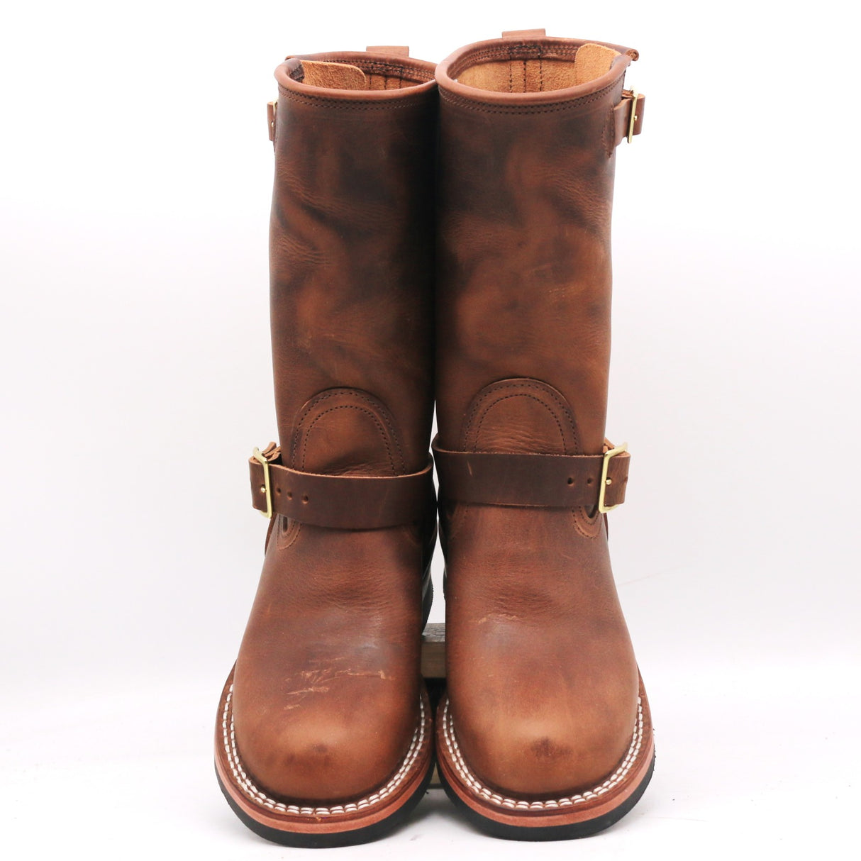 A pair of mid-calf brown leather boots with buckle straps, photographed against a plain white background.