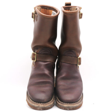 A pair of dark brown leather ankle boots with double buckle straps and brass hardware, shown against a plain white background.