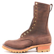 A brown leather lace-up work boot with brass eyelets, a pull tab, and a stacked tan and orange-brown sole, shown on a white background. The brand name 'NICKS' is embossed on the side.