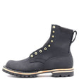 A black suede lace-up ankle boot with gold-tone metal eyelets and studs, a pull tab at the heel, and a rugged black lug sole with a light tan midsole stripe, shown against a plain white background.
