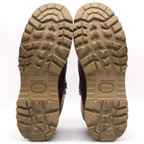 A pair of rugged brown boots shown from the sole view, featuring deep lugs and a tan Vibram outsole on a white background.