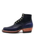 A navy blue leather ankle boot with gold-tone metal eyelets, a stacked brown wooden heel, and a black sole, shown from a side profile on a white background.