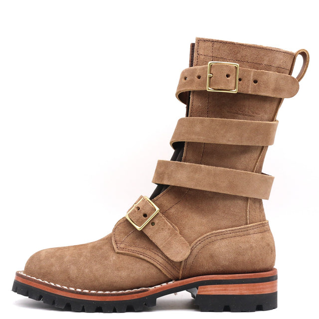 A mid-calf brown suede boot with multiple decorative straps and gold-tone buckle details, set against a plain white background.