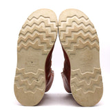 The soles of a pair of brown leather boots, shown from the bottom against a white background. The soles are a light beige/tan color with a zigzag tread pattern, and the brand name 'NICKS' is embossed in the center.