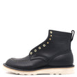 A black leather ankle boot with gold-tone metal eyelets, white contrast stitching, and a thick off-white sole, shown from a side profile on a white background.