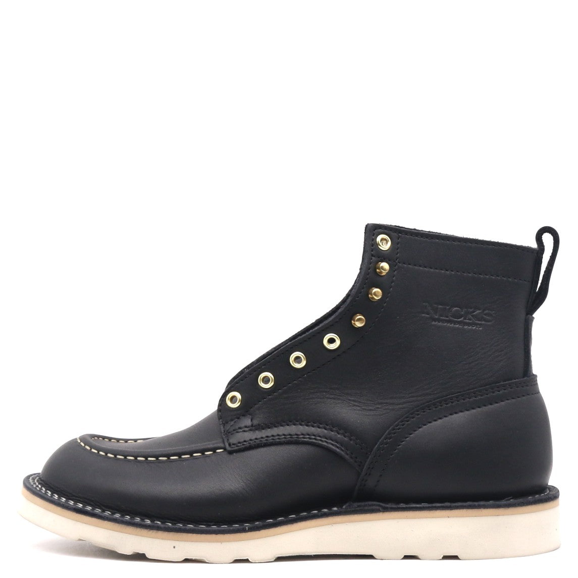 A black leather ankle boot with gold-tone metal eyelets, white contrast stitching, and a thick off-white sole, shown from a side profile on a white background.