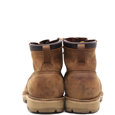 A pair of brown leather ankle boots shown from the back, featuring a pull tab, dark collar lining, and thick lug soles, set against a plain white background.