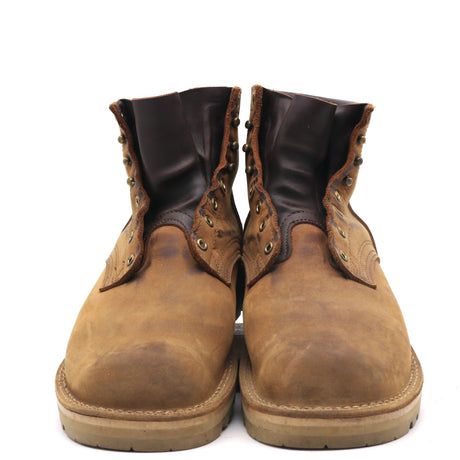 A pair of men's lace-up ankle boots in distressed brown leather with dark brown leather collar panels and brass eyelets, shown from the front on a white background.
