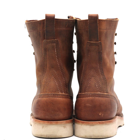 A pair of brown leather lace-up boots shown from the back, featuring a distressed finish and off-white soles, set against a plain white background.