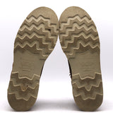 A pair of boots shown from the bottom, displaying their textured zig-zag treaded soles. The soles are a weathered tan-brown color with the brand name 'NICKS' clearly embossed in the center.