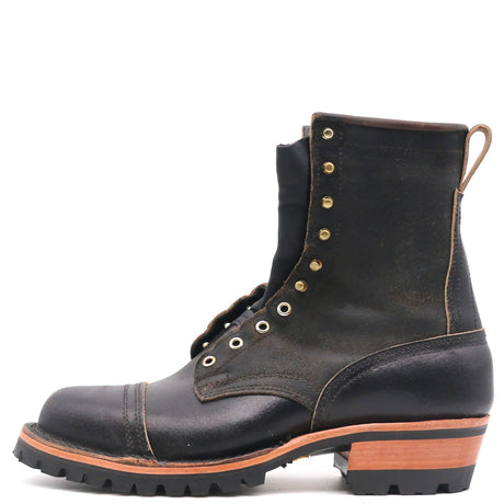 A single black leather lace-up boot with brass eyelets, a pull loop, and a stacked lug sole, shown from a side profile on a white background.